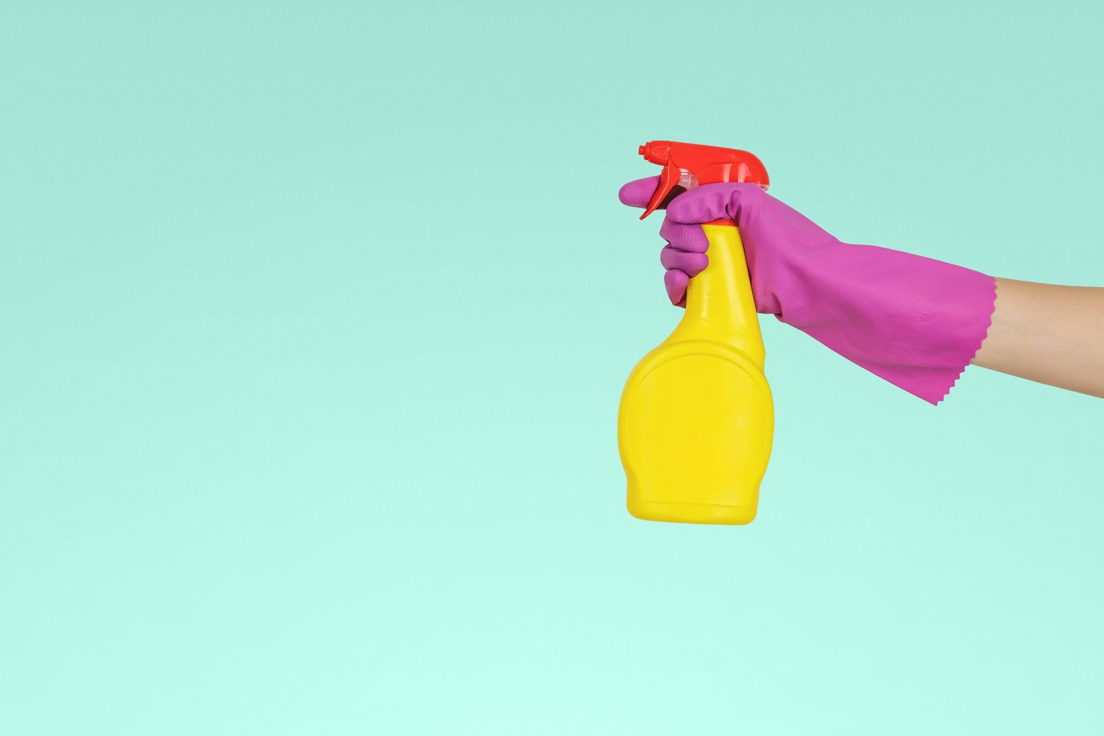 Gloved hand holding an unlabelled spray bottle